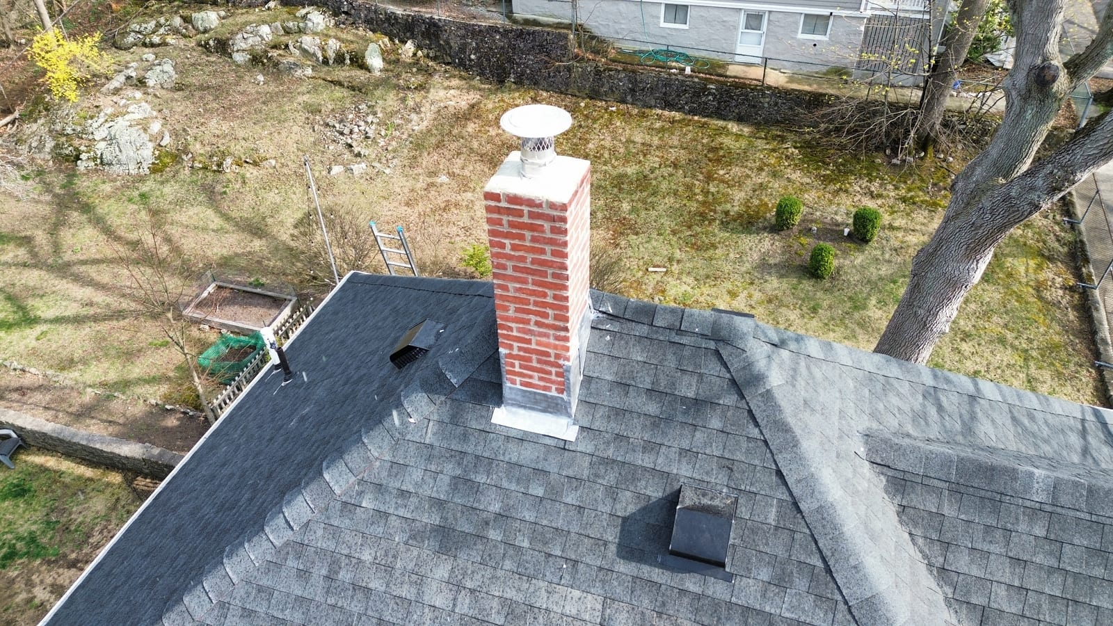 A finished brick chimney and the surrounding roof, both completed by De La Rosa